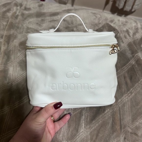 Arbonne Handbags - Arbonne White Cosmetic Bag with Gold Accents